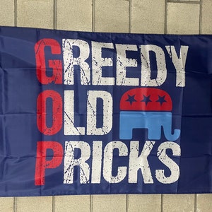 Può includere: Una bandiera blu con il testo "GOP GREEDY OLD PRICKS" in lettere bianche e rosse. Un elefante rosso e blu con tre stelle è al centro della bandiera.