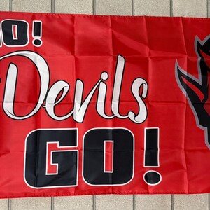 May include: Red flag with the words "GO! Devils GO!" in white and black. A devil head graphic is on the right side. The flag is rectangular and has a white border on the left side.