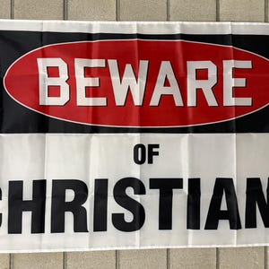 May include: White flag with black and red text. The top section features the word "BEWARE" in white letters inside a red oval on a black background. The bottom section reads "OF CHRISTIANS" in large black letters.