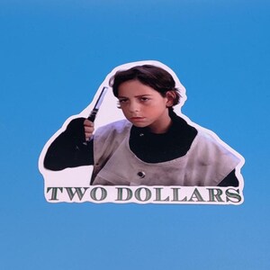 May include: A sticker featuring a young person holding a device, with the text "TWO DOLLARS" in green and white. The sticker has a white border and is set against a blue background.