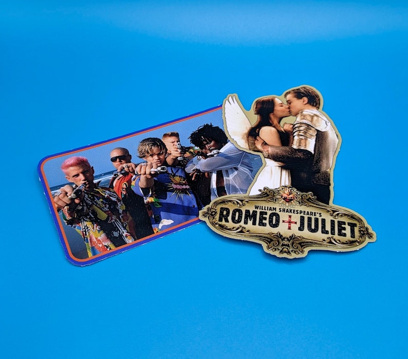 May include: A sticker featuring a scene from the film Romeo + Juliet, with a group of young men in the background and a couple kissing in the foreground. The sticker also includes the title "William Shakespeare's Romeo + Juliet" in a gold and red design.