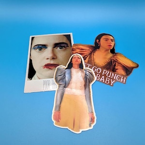 May include: Three stickers featuring a woman with dark hair and a white shirt. The stickers are on a blue background. The text on one sticker reads "Let go punch baby".