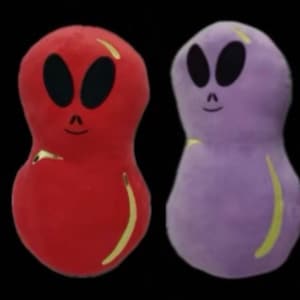 May include: Six plush alien toys in different colors: light blue, green, red, purple, pink and blue with white and pink swirls. Each alien has a round head with two black eyes and a smiling mouth.