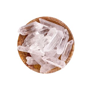 May include: A bowl filled with clear quartz crystal points. The bowl is made of brown stone with a marbled pattern.