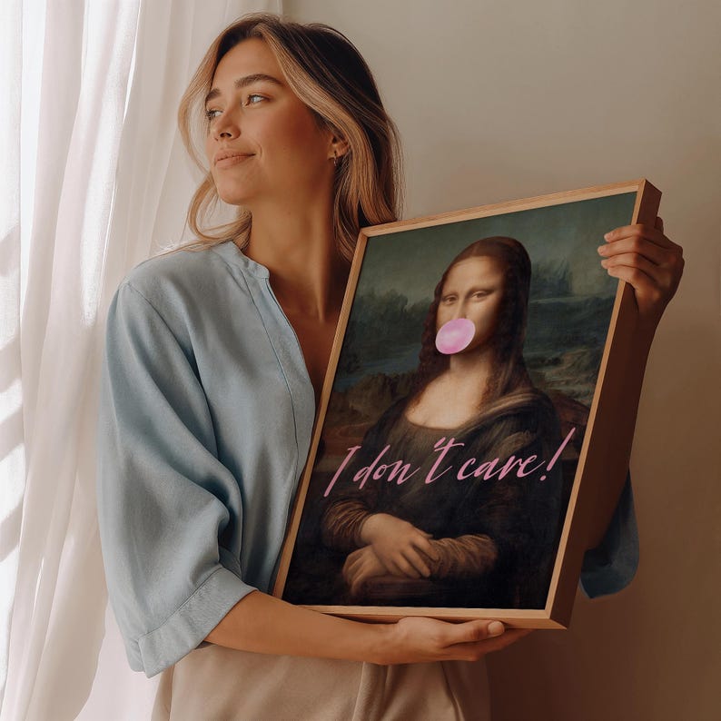 May include: A framed print of the Mona Lisa with a pink bubble gum added to her mouth. The print has the text "I don't care!" written in pink cursive.