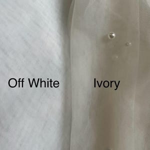 May include: Close-up of two swatches of fabric, one labeled "Off White" and the other labeled "Ivory". The ivory swatch has a slightly more yellow hue than the off-white swatch.