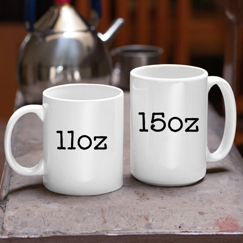 May include: Two white ceramic mugs with black text. The mug on the left says "11oz" and the mug on the right says "15oz".