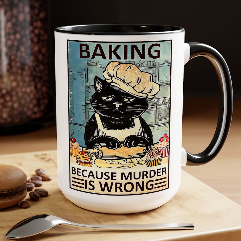 May include: White ceramic mug with a black handle and rim. The mug features a vintage-style illustration of a black cat wearing a chef's hat and apron, rolling out dough in a kitchen. The text "Baking because murder is wrong" is printed below the illustration.