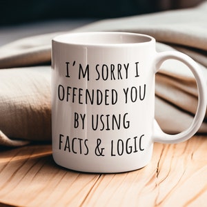 Peut inclure: Une tasse en céramique blanche avec du texte noir qui dit "Je suis désolé de t'avoir offensé en utilisant des faits et de la logique".