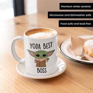 May include: White ceramic mug with a green cartoon character and the text "YODA BEST BOSS".