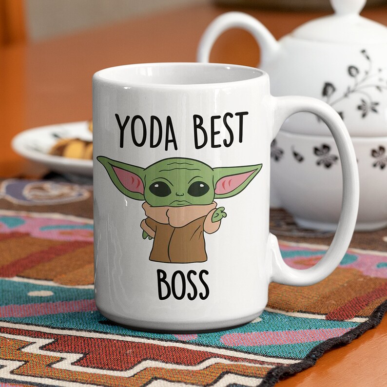 May include: White ceramic mug with a green cartoon character with large ears and the text "YODA BEST BOSS" printed on it.