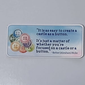 May include: A motivational quote card with a blue, pink, and white watercolor background. The quote reads, "It is as easy to create a castle as a button. It's just a matter of whether you're focused on a castle or a button." - Esther (Abraham) Hicks. The card features a colorful illustration of buttons.