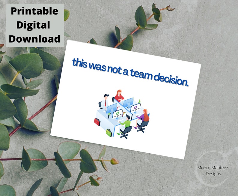 Op de afbeelding: Een witte kaart met de tekst "this was not a team decision" in blauw. De kaart bevat een illustratie van mensen die aan computers werken. De woorden "Printable Digital Download" staan linksboven.