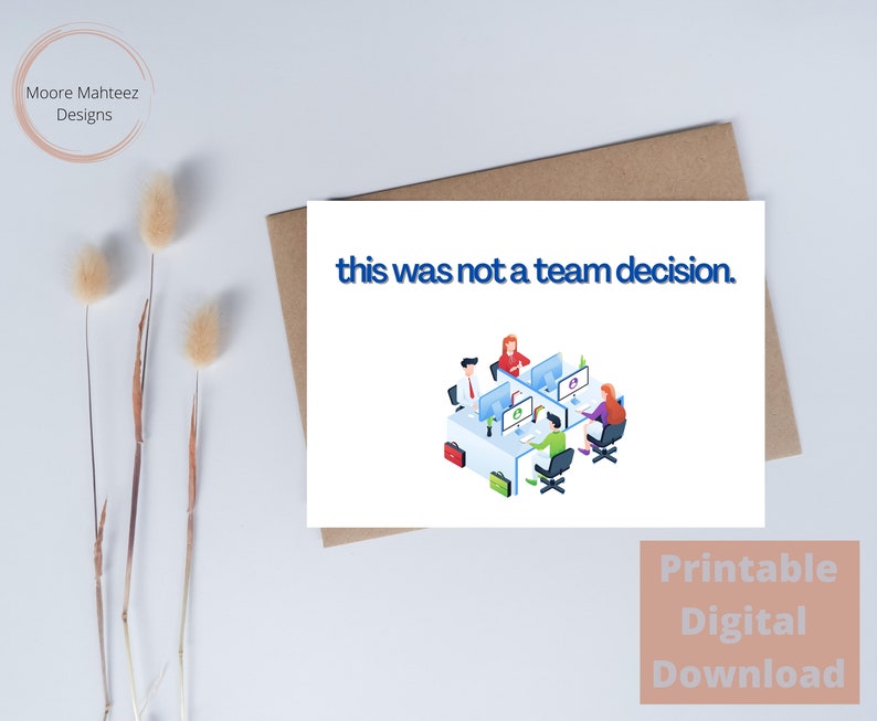 Op de afbeelding: Een witte wenskaart met de tekst "this was not a team decision" in het blauw. De kaart toont een illustratie van vier mensen die aan computers werken. De kaart ligt op een bruine envelop.