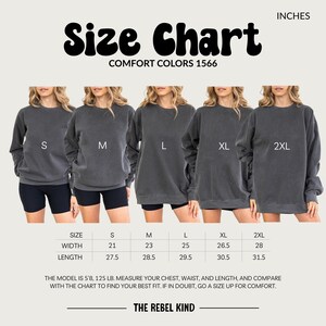 May include: Size chart for Comfort Colors 1566 sweatshirts. The chart displays measurements in inches for sizes S, M, L, XL, and 2XL. The image shows models wearing the sweatshirts. The text also includes the brand name, and instructions for measuring and finding the best fit.