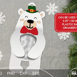 May include: A white polar bear-shaped ornament holder with a red bow tie and a green hat. The text "CAN BE USED WITH 3.15" | 80 MM PLASTIC BALL ORNAMENTS" is displayed on a red background. Includes SVG, PNG, DXF, and EPS file formats.