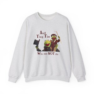 May include: A light gray sweatshirt featuring a graphic of Kermit the Frog and another frog character dressed in a suit and hat. The text "And Tiny Tim Who did NOT die" is printed above and below the characters.