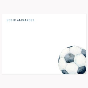 May include: White stationery with the name "BODIE ALEXANDER" in dark blue text at the top. A watercolor illustration of a soccer ball is in the bottom right corner. The ball is white with gray and black pentagons.