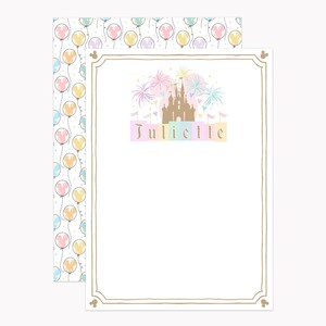 May include: A rectangular stationery card with a gold border and a central illustration of a tan castle with pastel fireworks above it. The name Juliette is printed in brown below the castle. The back sheet features a pattern of balloons.