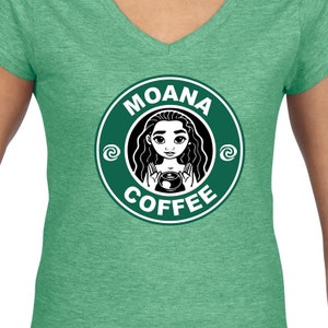 Puede incluir: Camiseta verde con un gr&aacute;fico en blanco y negro de Moana sosteniendo una taza de caf&eacute;. El gr&aacute;fico est&aacute; en el estilo del logotipo de Starbucks y dice "Moana Coffee".
