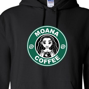 Puede incluir: Sudadera negra con un logotipo circular verde que presenta una imagen de dibujos animados de Moana sosteniendo una taza de caf&eacute;. El logotipo dice "Moana Coffee" en texto blanco.