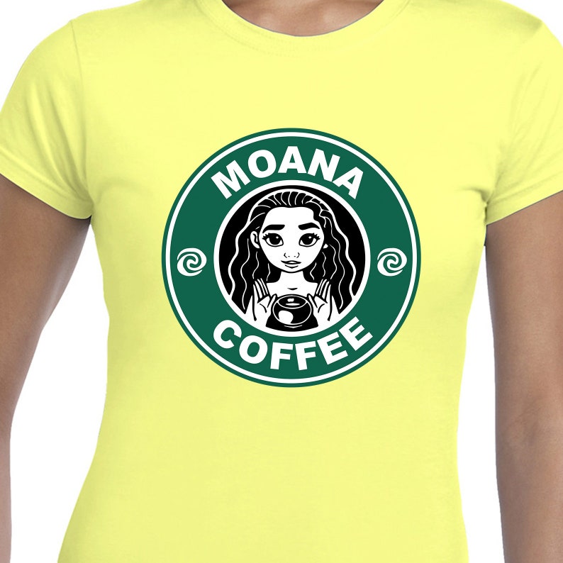 Puede incluir: Una camiseta amarilla con un logotipo verde y blanco que dice "Moana Coffee". El logotipo presenta una imagen de dibujos animados de Moana sosteniendo una taza de caf&eacute;.