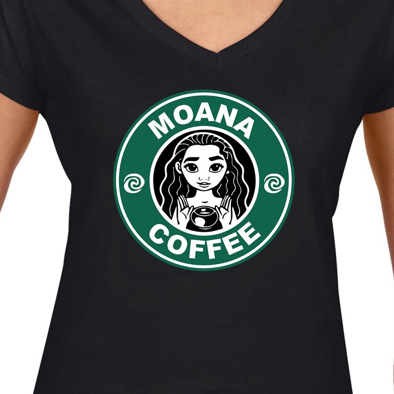 Puede incluir: Camiseta negra con un logotipo verde y blanco que dice "Moana Coffee". El logotipo presenta una imagen de dibujos animados de Moana sosteniendo una taza de caf&eacute;.
