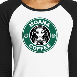 Puede incluir: Una camiseta de estilo b&eacute;isbol blanca y negra con un logotipo circular verde. El logotipo tiene el texto "MOANA COFFEE" y una imagen de dibujos animados de Moana sosteniendo una taza de caf&eacute;.