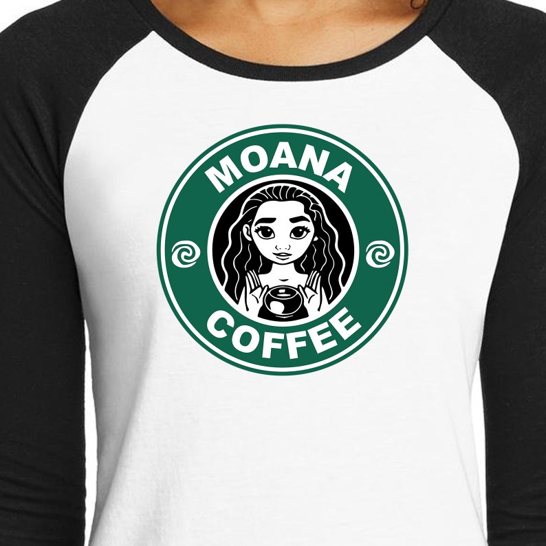 Puede incluir: Una camiseta de estilo b&eacute;isbol blanca y negra con un logotipo circular verde. El logotipo tiene el texto "MOANA COFFEE" y una imagen de dibujos animados de Moana sosteniendo una taza de caf&eacute;.