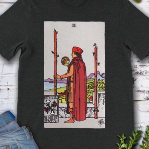 Camiseta con la carta del Tarot Dos de Bastos, original de Rider Waite, dibujada a mano.