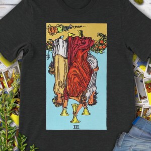 Carta del Tarot Tres de Copas Vintage invertida: la camiseta original de la baraja Rider Waite dibujada a mano.
