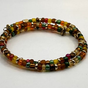 May include: A multi-strand beaded bracelet with a mix of brown, orange, yellow, green, and gold beads.