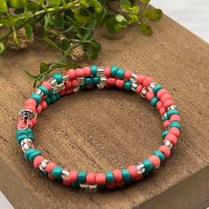 May include: A double-wrap beaded bracelet with alternating coral and teal beads and silver accents.
