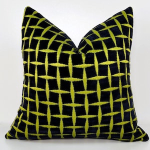 May include: A black velvet pillow with a geometric pattern of lime green embroidered lines. The pillow is square and has a subtle sheen.