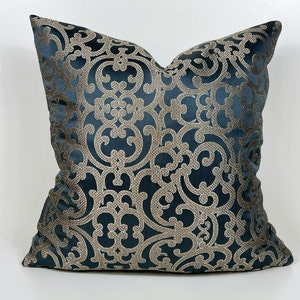 May include: A teal blue throw pillow with a gold damask pattern. The pillow is square and has a soft, plush texture.