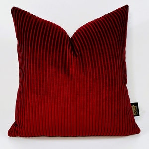 May include: Red velvet pillow with a ribbed texture. The pillow has a "Happy Home" logo in the bottom right corner.