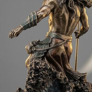 May include: Bronze statue of a muscular figure, possibly a god, with long hair and a crown, holding a trident. The figure is emerging from stylized waves. The statue has a detailed, aged appearance.