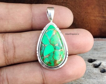 May include: A teardrop-shaped pendant with a green turquoise stone set in sterling silver. The stone has a unique pattern of green and gold.