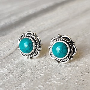 Könnte beinhalten: Ein Paar silberne Ohrringe mit türkisfarbenen Steinen, die in einem dekorativen, seilartigen Design eingefasst sind.