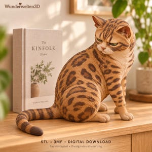 May include: A brown and tan spotted cat figurine with a striped tail, sitting next to a book titled The Kinfolk Home. The text Wunderwelten3D is visible at the top, and STL + 3MF DIGITAL DOWNLOAD is printed at the bottom.