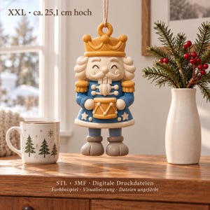 Può includere: Un ornamento schiaccianoci sospeso con corona gialla, giacca blu e un tamburo. Il testo recita XXL • ca. 25,1 cm hoch e STL + 3MF • Digitale Druckdateien Farbbeispiel • Visualisierung • Dateien ungefärbt.