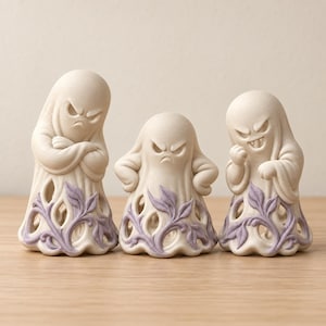 Peut inclure: Trois figurines de fantômes blanc cassé avec des expressions faciales en colère. Chaque fantôme présente une base ajourée décorée de motifs de vignes et de feuilles violet clair en relief. Le plus grand fantôme est à gauche, les bras croisés.