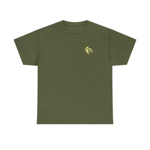 May include: Olive green t-shirt with a crew neck and short sleeves. A small, yellow mountain graphic with the letters "BC" is printed on the upper left chest area. The shirt is made of a soft, comfortable material.