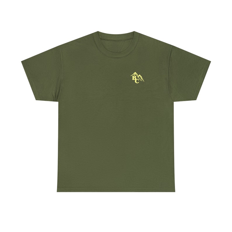 May include: Olive green t-shirt with a crew neck and short sleeves. A small, yellow mountain graphic with the letters "BC" is printed on the upper left chest area. The shirt is made of a soft, comfortable material.