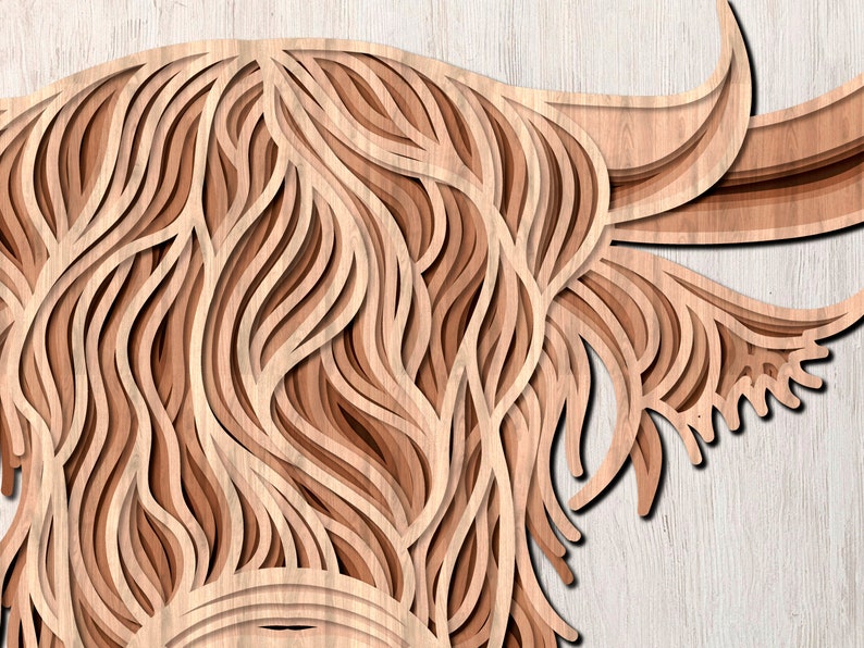 May include: A close-up of a wooden cutout of a Highland cow's head. The cutout is layered to create a 3D effect, with the fur of the cow being represented by intricate, layered lines.