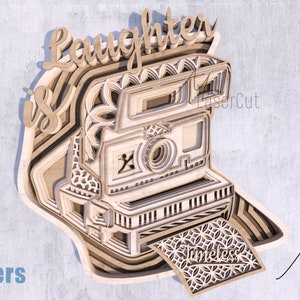 May include: A layered wooden cutout design of an instant camera with the words "laughter is timeless" and a floral pattern. The design is made for laser cutting and comes in 6 layers.