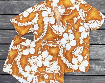 Conjunto de baño hawaiano tipo cabaña con camisa corta y estampado floral de hibisco.