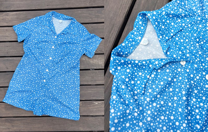 Puede incluir: Un vestido de manga corta azul y blanco con lunares, cuello y cierre de botones.