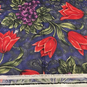 May include: Fabric with a floral pattern featuring red tulips, purple grapes, and green leaves on a blue background. The fabric has the text "IMPRESSIONS by Patricia B. Campbell and Michelle & Jack for BENARTEX, Inc. 100% Cotton Screen Prints".