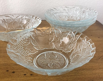 May include: Three clear glass bowls with a floral design. The bowls are stacked on top of each other.